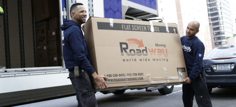 movers carrying a box when moving from Brooklyn to Manhattan