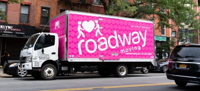 A pink moving truck on the street