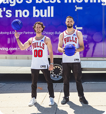 Two movers standing together with a basketball
