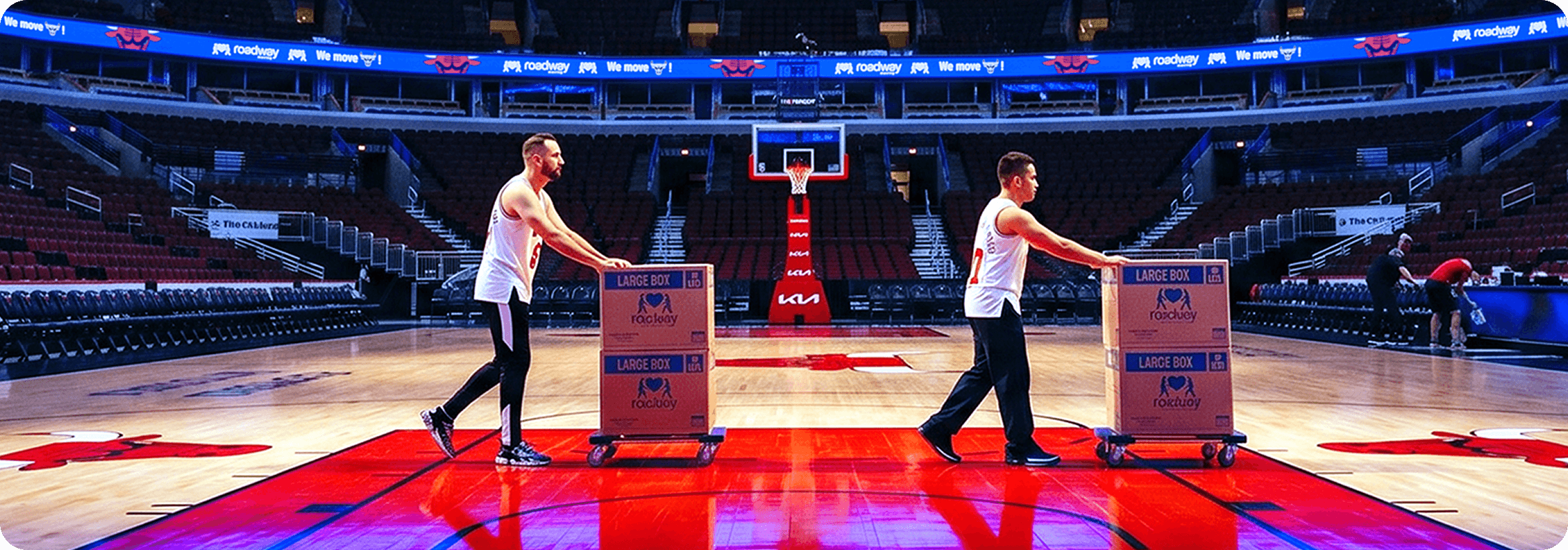 Movers rolling Roadway Moving boxes across the United Center court