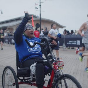 Hand-cyclist celebrating while crossing the finish line