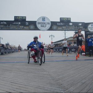 Long shot of Hand-cyclist crossing the finish line