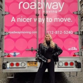 Happy customer in front of Roadway Moving's truck